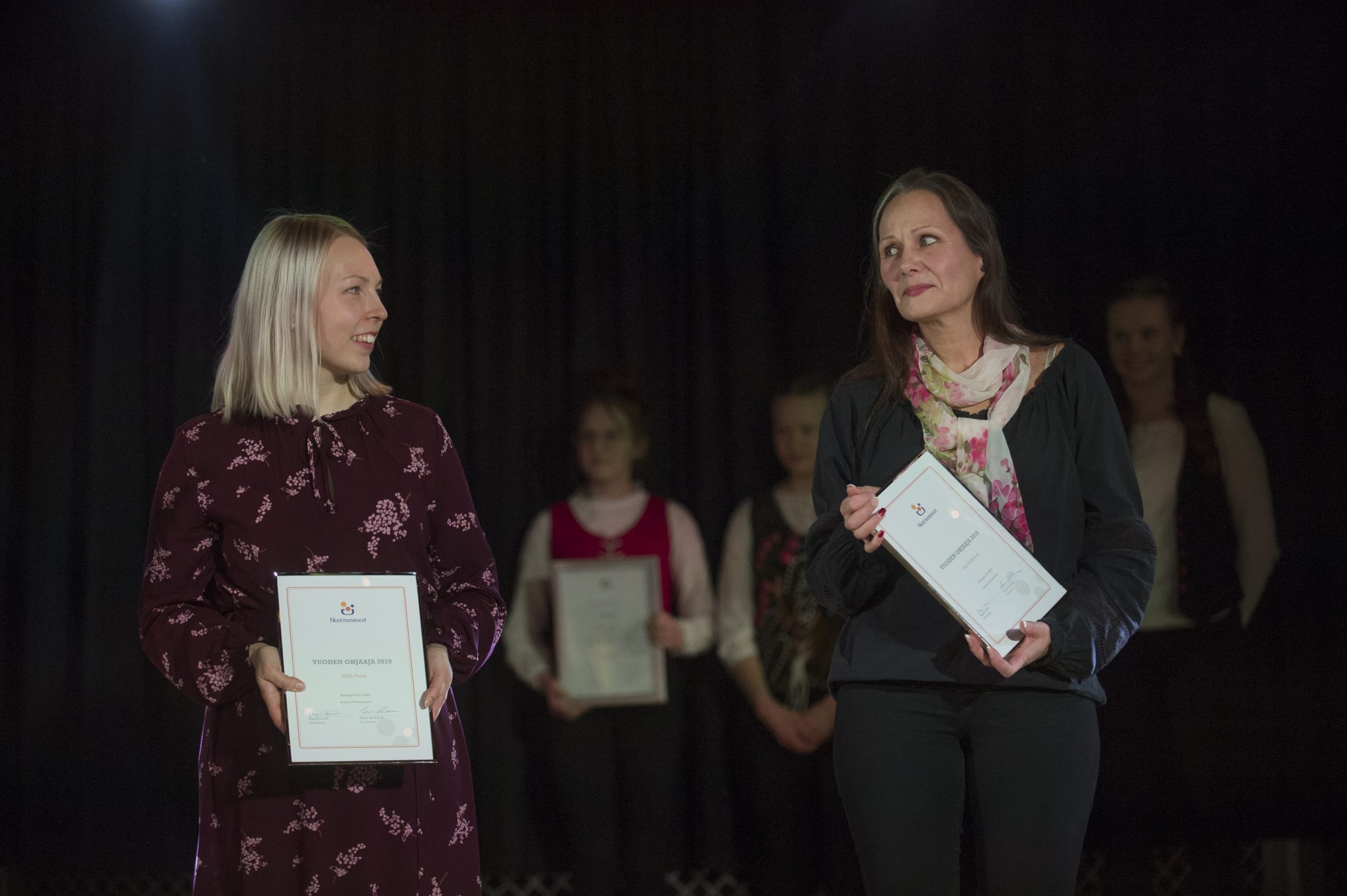 vuoden ohjaajat1 Vuoden ohjaajat Milla Sorsa ja Arja Söderlund hymyilevät ja katsovat toisiaan kunniakirjat kädessään.