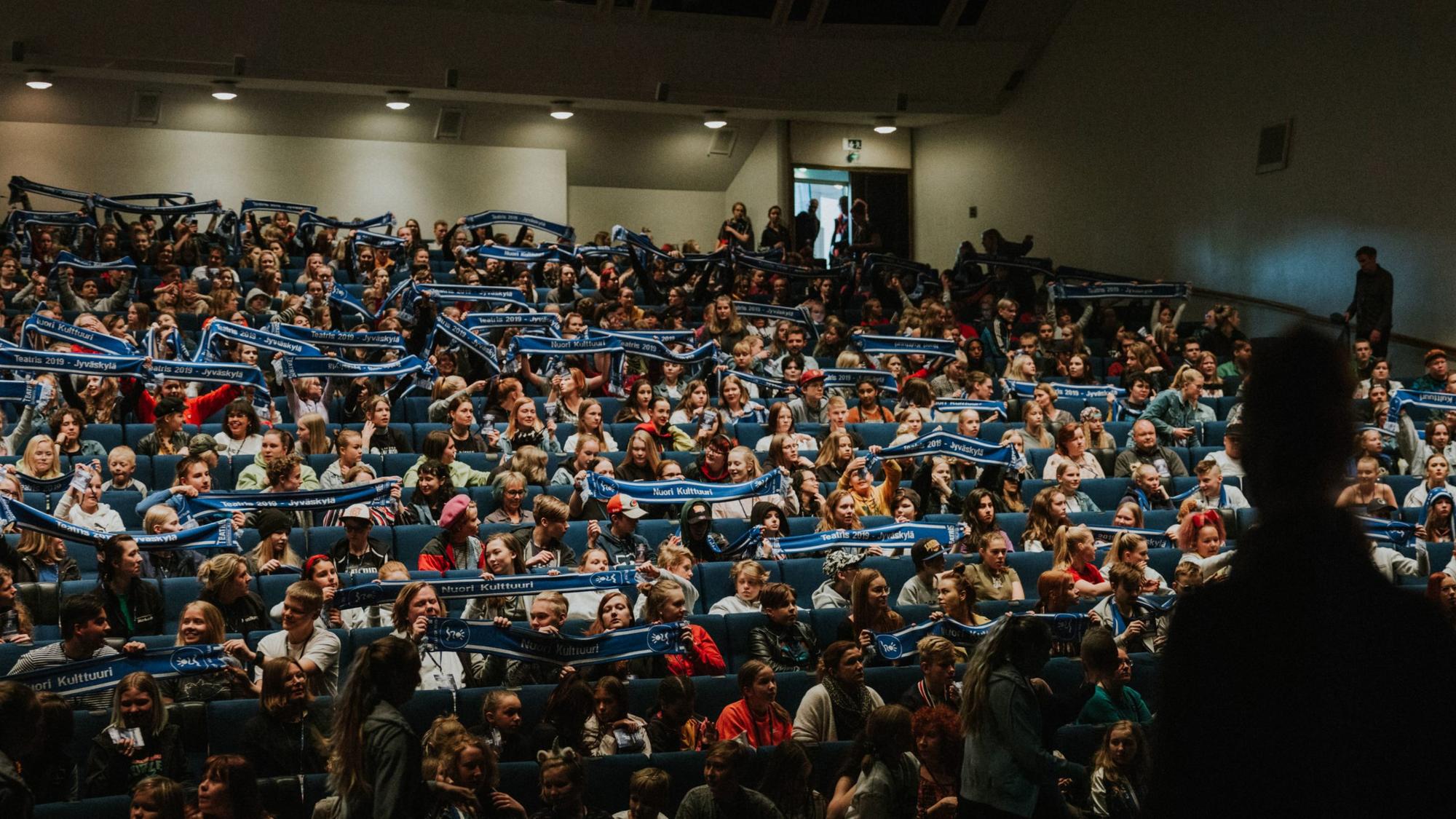 Salissa suuri joukko heiluttelee Nuori kulttuuri kaulaliinoja.