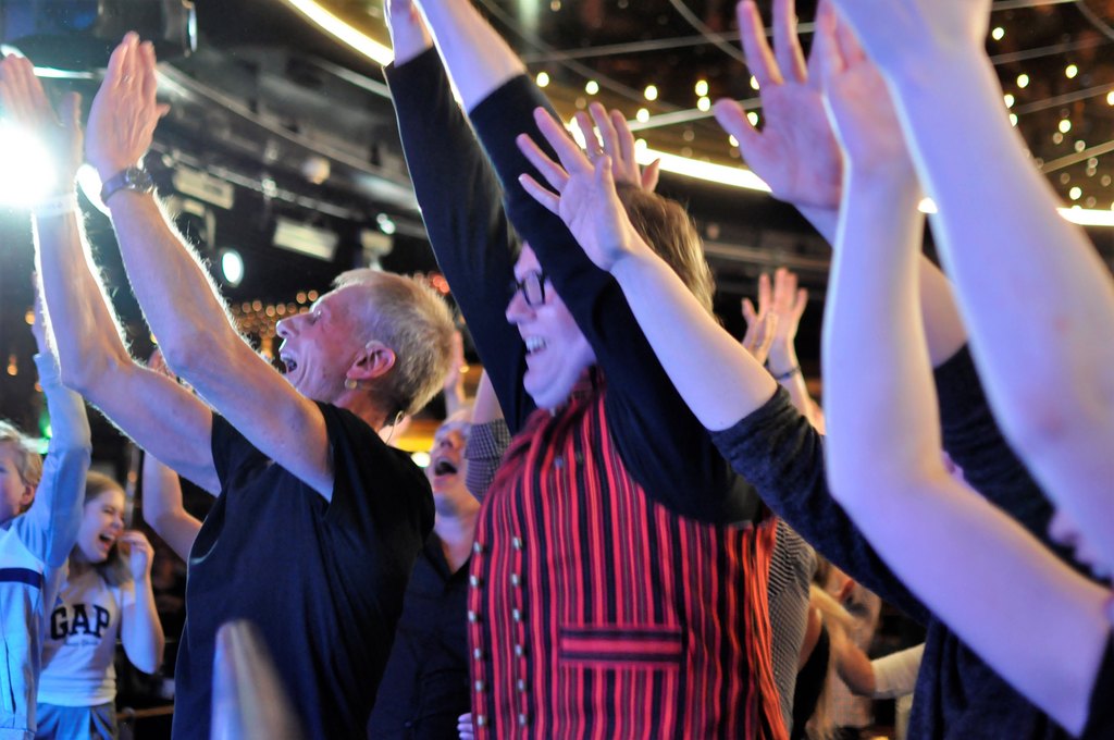 Ihmisiä tanssimassa huutokatrillia kädet ilmassa.