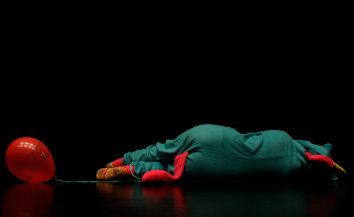 Kohtaus näytelmästä rakas painajainen: ihminen makaa lattialla